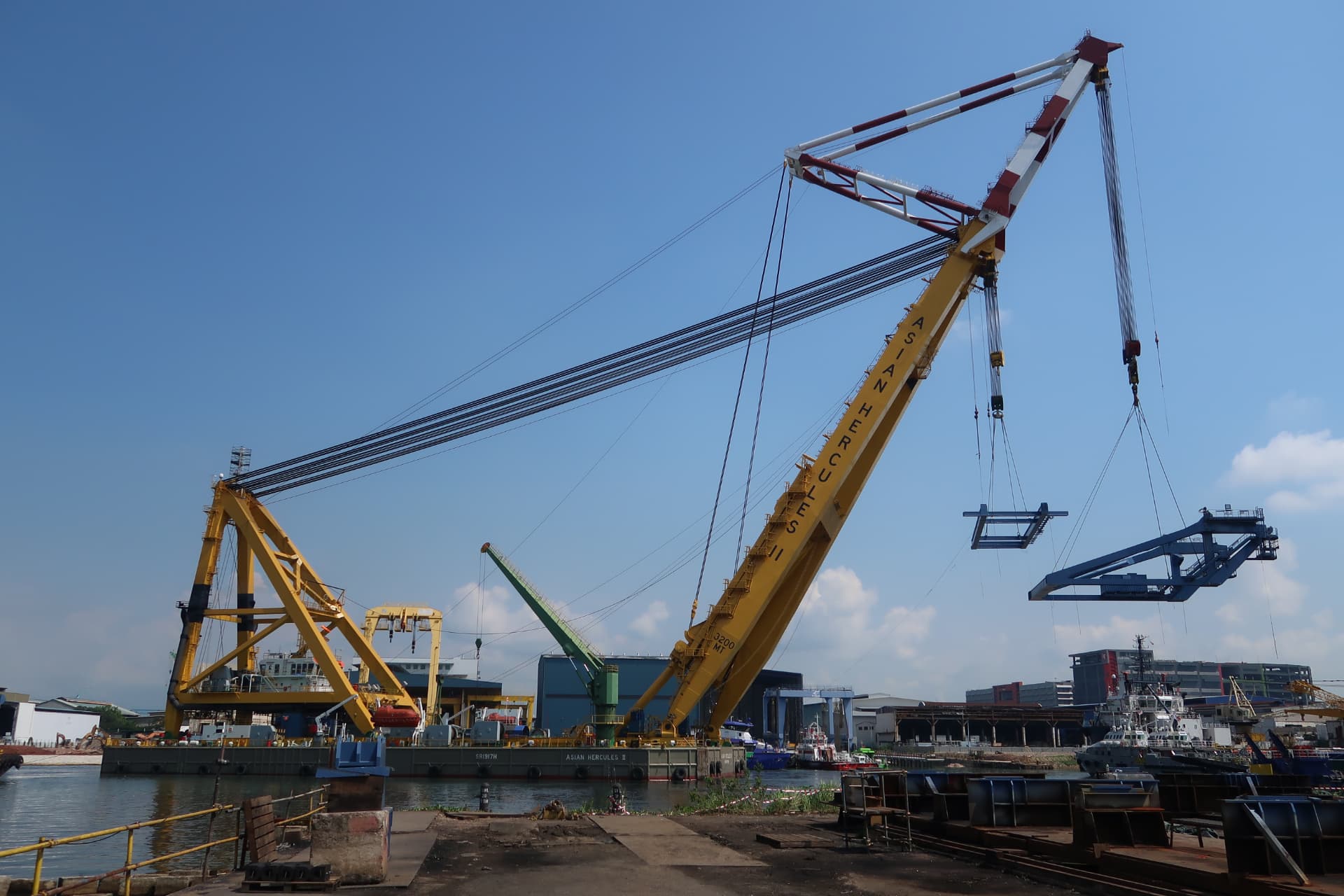 Floating sheerleg crane performing a heavy lift in port